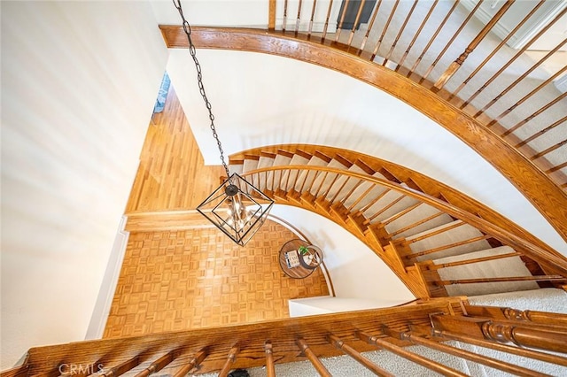 staircase with a notable chandelier