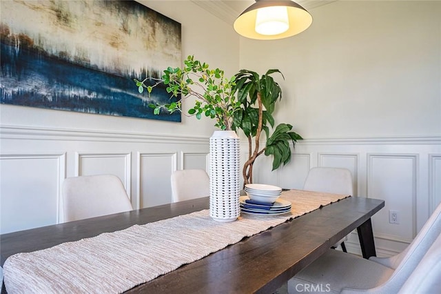 dining space featuring wainscoting and a decorative wall