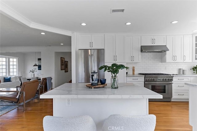 kitchen with light wood finished floors, visible vents, stainless steel appliances, under cabinet range hood, and white cabinetry