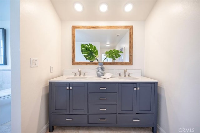 full bathroom with a sink, baseboards, and double vanity