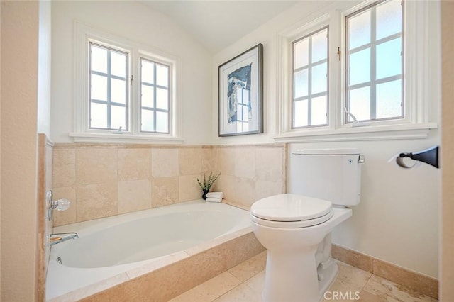 full bath with toilet, lofted ceiling, a bath, and baseboards