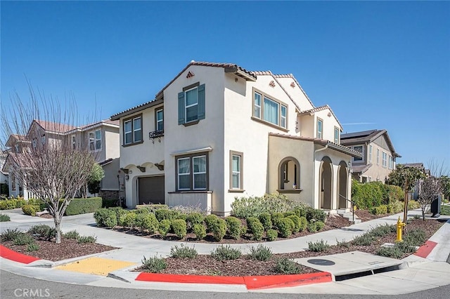 view of front of home featuring a garage, a residential view, driveway, and stucco siding