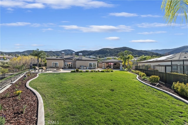 view of yard featuring a fenced backyard, a residential view, a mountain view, and a patio