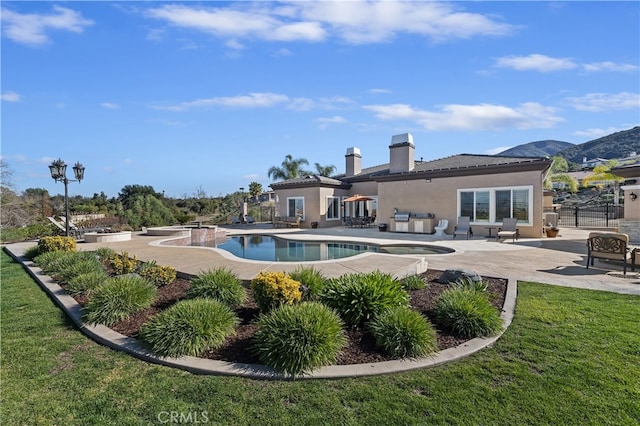 back of property featuring a patio area, a lawn, an outdoor pool, and stucco siding