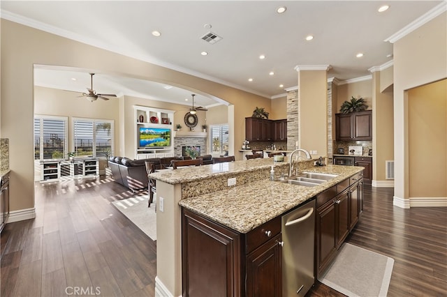 kitchen featuring a fireplace, backsplash, open floor plan, a kitchen island with sink, and a sink