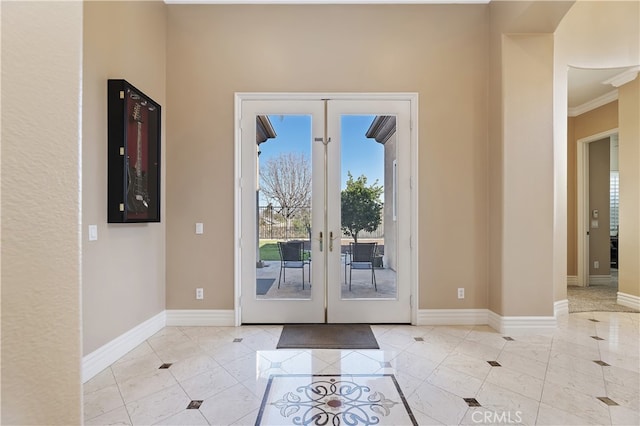 entryway with ornamental molding, french doors, baseboards, and light tile patterned floors