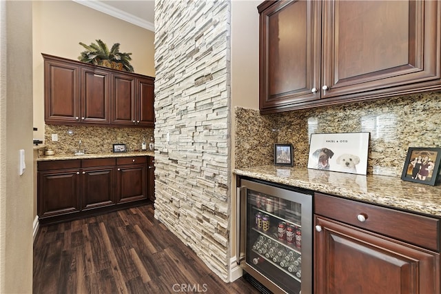 bar with dark wood-style floors, wine cooler, a dry bar, tasteful backsplash, and ornamental molding