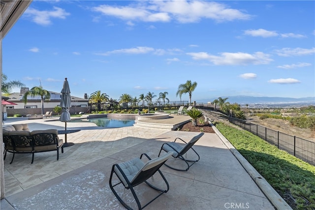 view of property's community featuring a patio, a mountain view, fence, a pool, and a hot tub