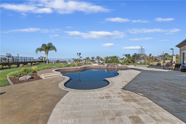 outdoor pool with a patio area and fence