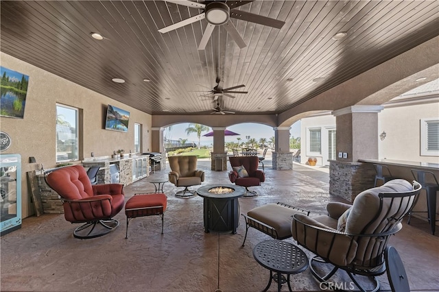 view of patio / terrace with a ceiling fan and a fire pit