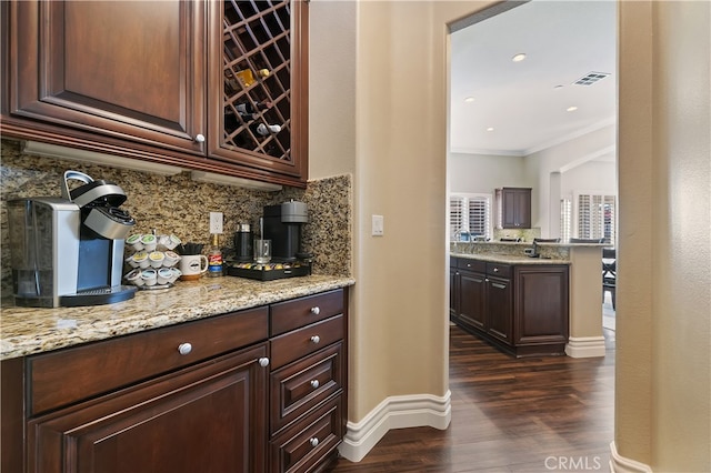 bar featuring visible vents, baseboards, ornamental molding, decorative backsplash, and dark wood-style floors