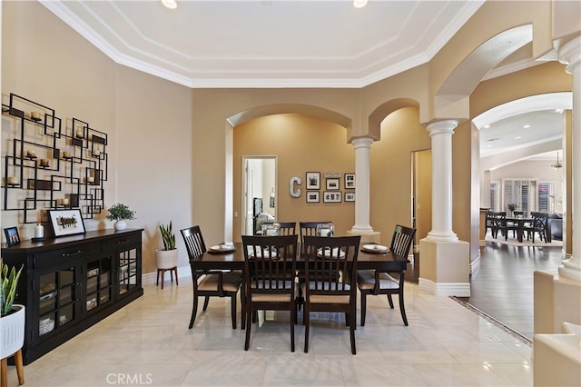 dining room featuring ornamental molding, baseboards, and ornate columns