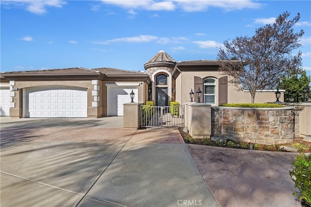 view of front of home featuring a garage, concrete driveway, a tiled roof, a gate, and stucco siding