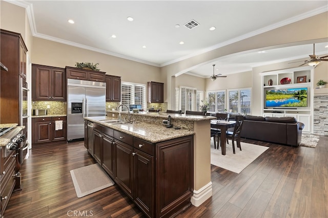 kitchen with dark brown cabinetry, visible vents, a spacious island, open floor plan, and stainless steel built in refrigerator