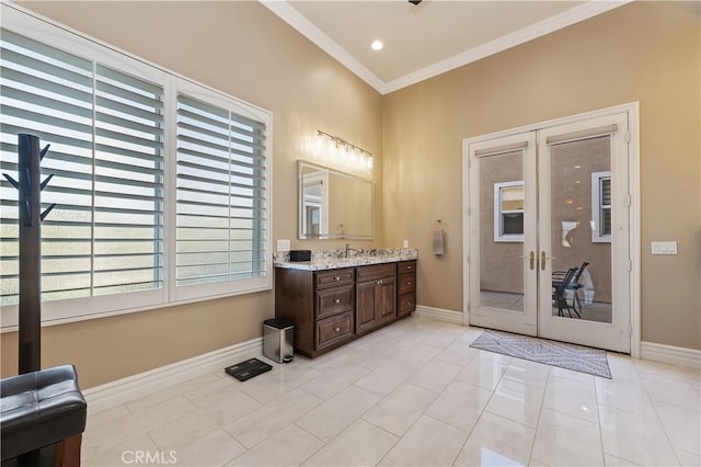 bathroom with baseboards, french doors, vanity, and crown molding