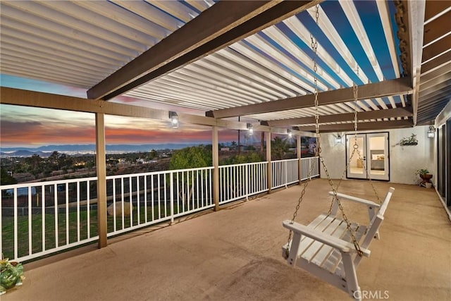 patio terrace at dusk with fence and a pergola