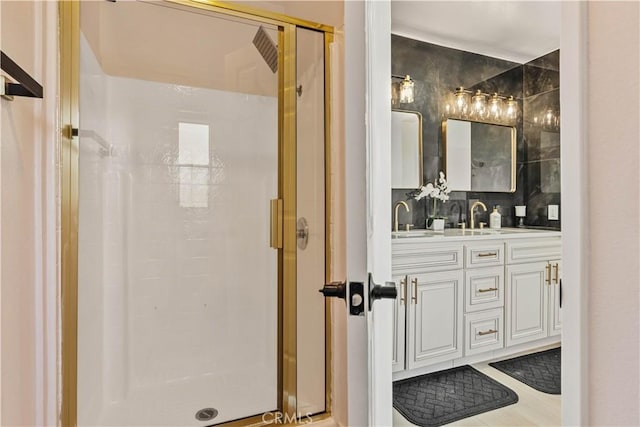 full bath with backsplash, a sink, a shower stall, and double vanity