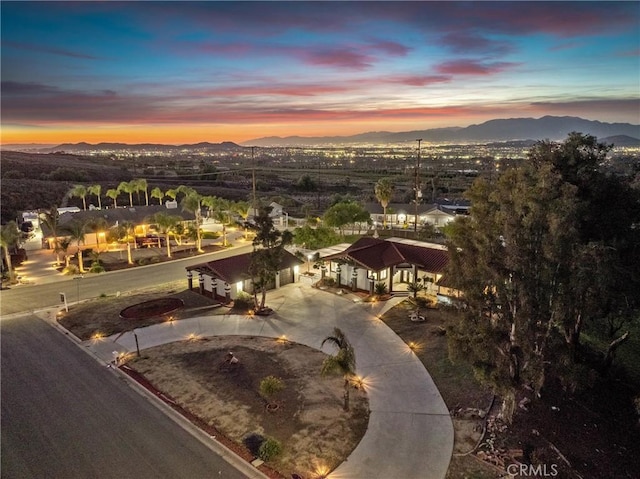 aerial view at dusk featuring a mountain view