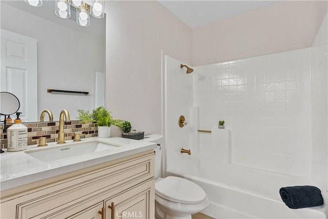 bathroom featuring vanity, tub / shower combination, backsplash, and toilet