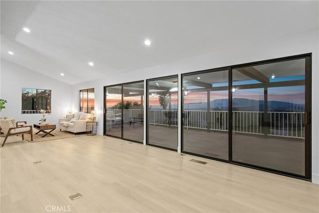 interior space featuring lofted ceiling, recessed lighting, visible vents, and light wood-style floors