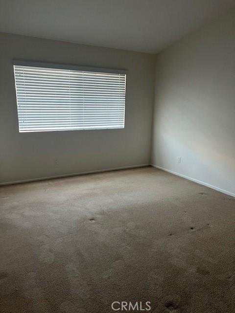 carpeted empty room with baseboards