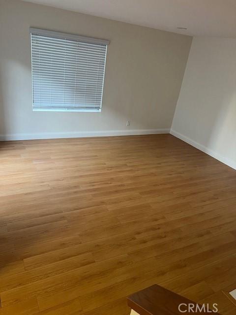 spare room with light wood finished floors and baseboards