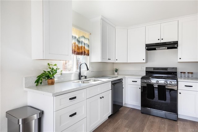 kitchen featuring black dishwasher, range with gas cooktop, light countertops, under cabinet range hood, and a sink