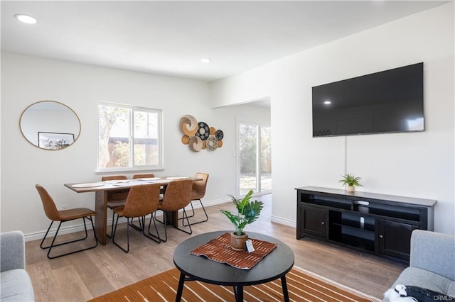 living area with light wood-type flooring, baseboards, and recessed lighting