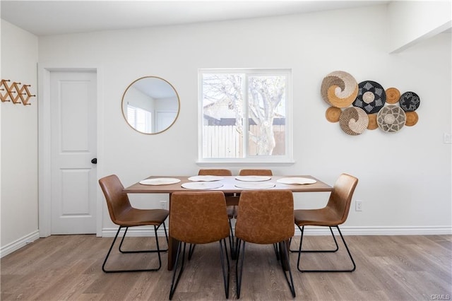 dining room featuring baseboards and light wood finished floors