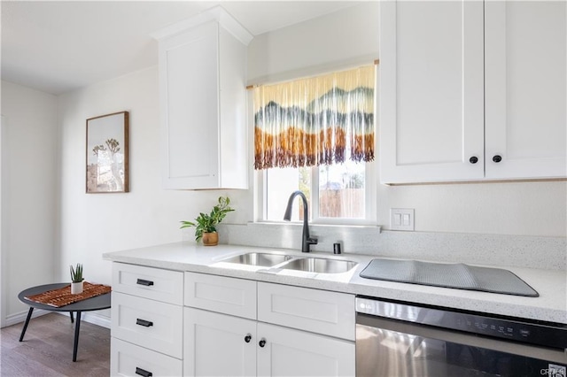 kitchen featuring light countertops, light wood-type flooring, a sink, and white cabinets