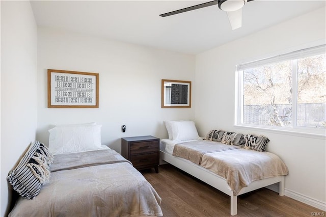 bedroom with ceiling fan, baseboards, and dark wood-style flooring