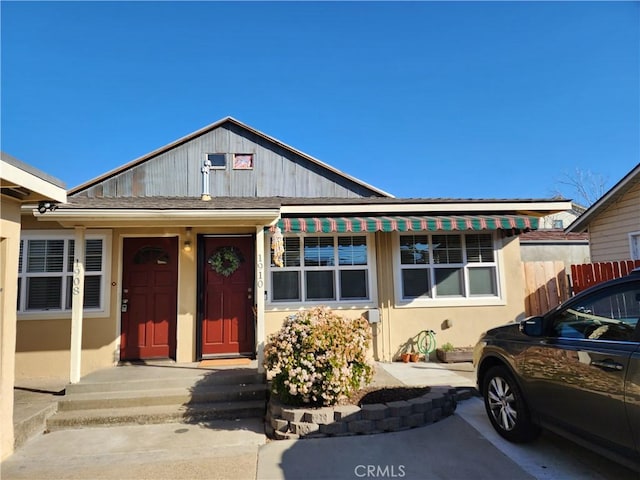 bungalow-style home with stucco siding