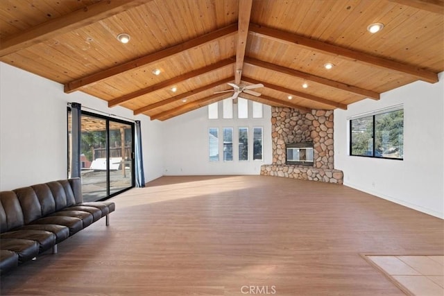 unfurnished living room with vaulted ceiling with beams, a stone fireplace, plenty of natural light, and wood ceiling