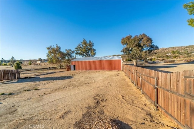 view of yard with a pole building, fence, and an outdoor structure