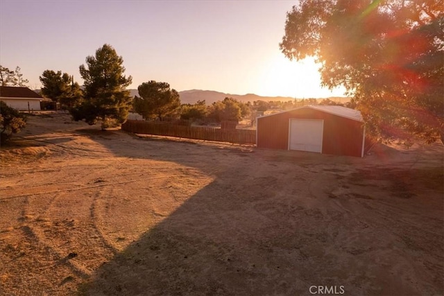 view of yard featuring a mountain view, an outdoor structure, and fence