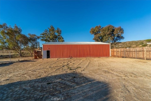 view of yard featuring fence and an outbuilding