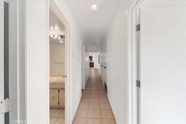 hallway with a sink and light tile patterned floors