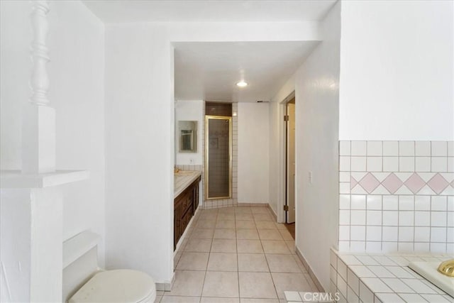 full bathroom with a stall shower, vanity, toilet, and tile patterned floors