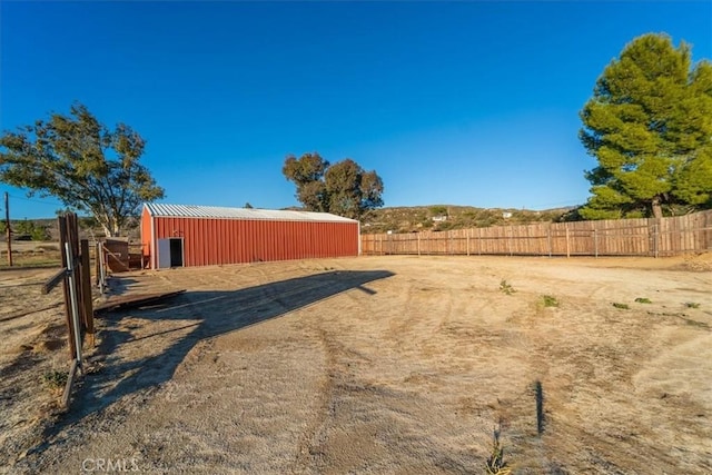 view of yard with fence and an outbuilding