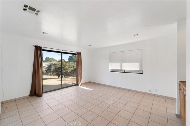 spare room featuring light tile patterned floors and visible vents