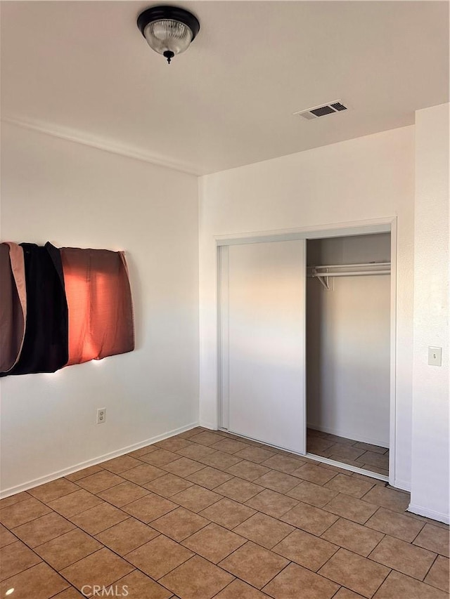 unfurnished bedroom featuring baseboards, visible vents, and a closet