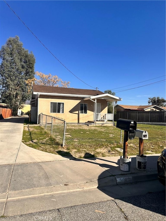 view of front of house featuring a front lawn, fence, and stucco siding