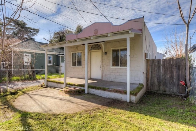 bungalow-style house with metal roof, a patio, a front lawn, and fence