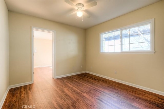 unfurnished room with a ceiling fan, baseboards, and wood finished floors