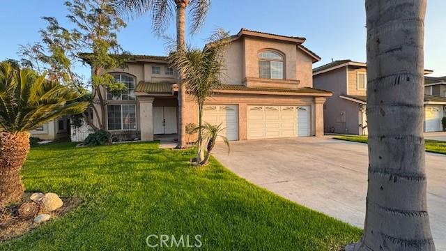 view of front facade with an attached garage, stucco siding, concrete driveway, and a front yard