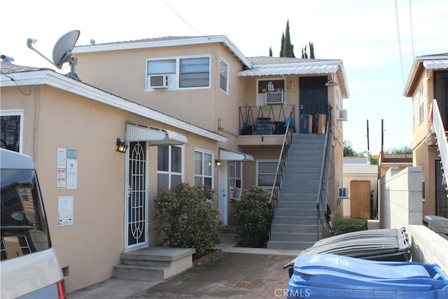 view of side of property featuring stairs and stucco siding