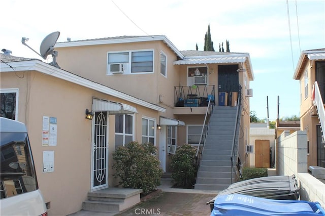 multi unit property featuring stairway and stucco siding