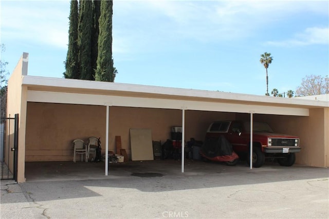 view of car parking with driveway and a carport