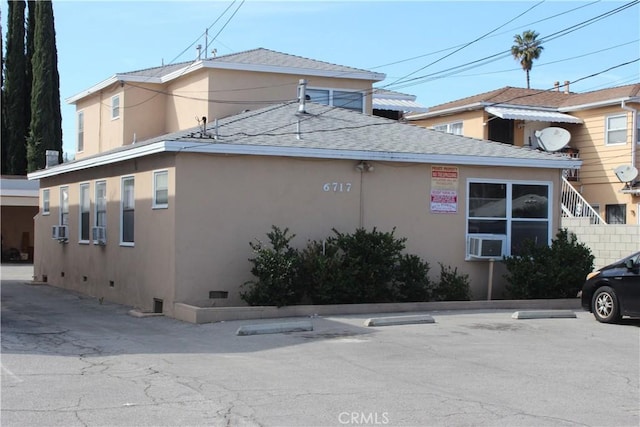 view of property exterior featuring crawl space, roof with shingles, cooling unit, and stucco siding