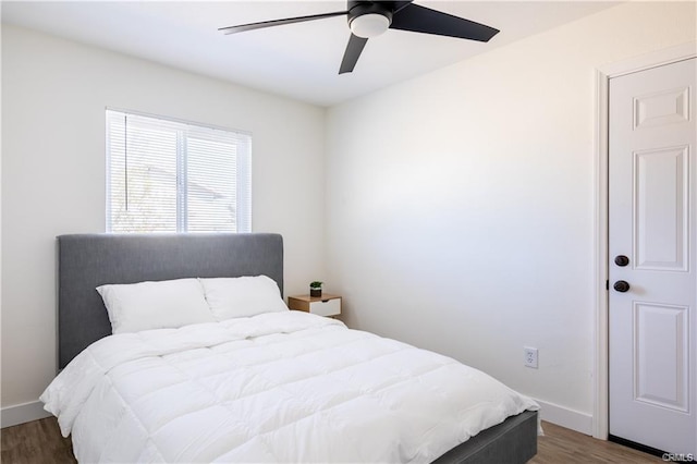 bedroom featuring dark wood-style floors, ceiling fan, and baseboards